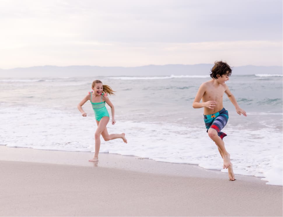 Two kids running on the beach